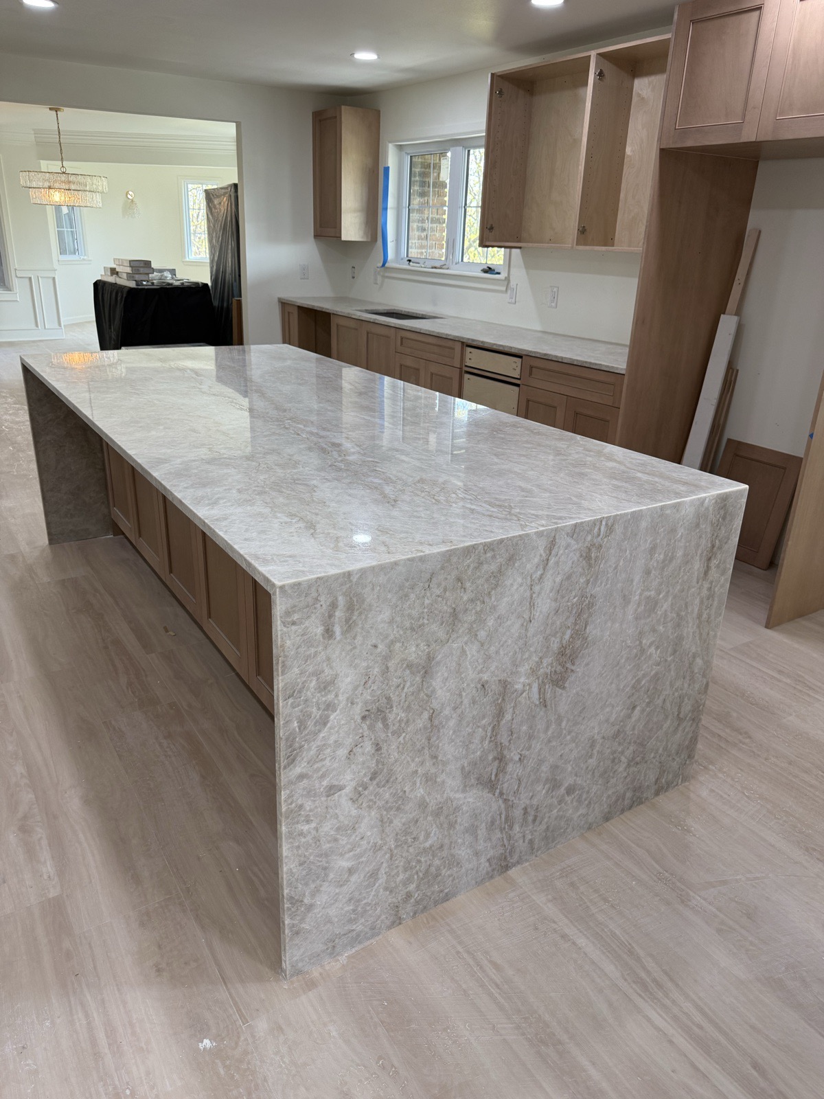 Custom quartzite island in light wood cabinet kitchen