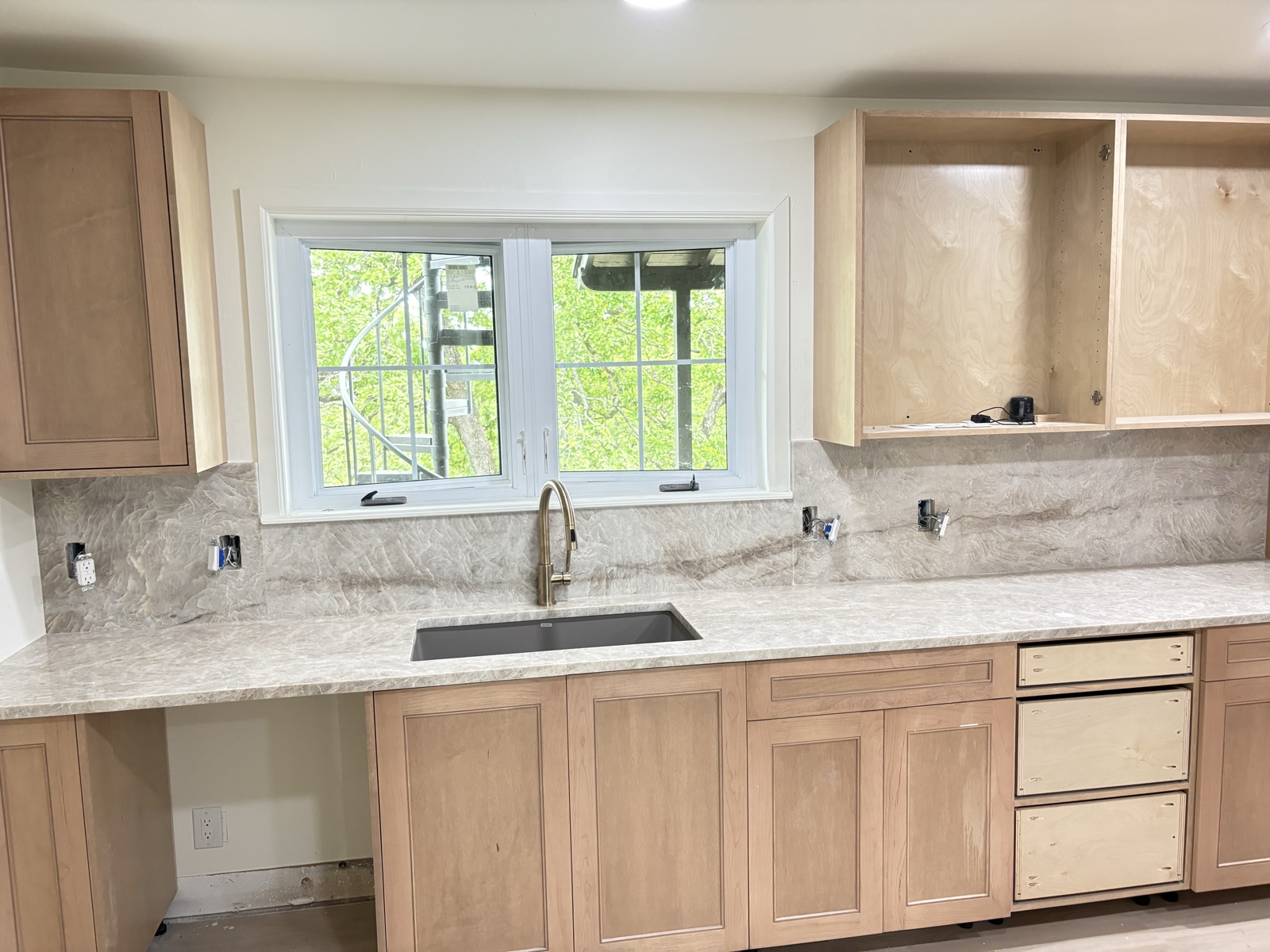 Light kitchen with cream quartzite countertops and full-slab backsplash
